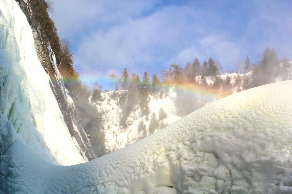 Un arc en ciel se forme à la chute Montmorency en hiver