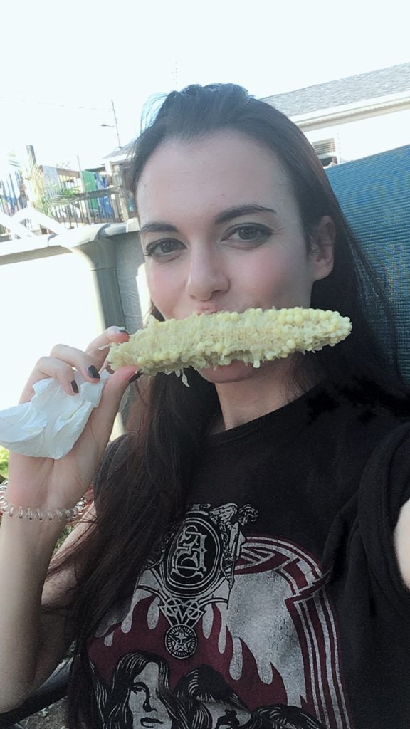 Jeune femme qui mange un épis de maïs