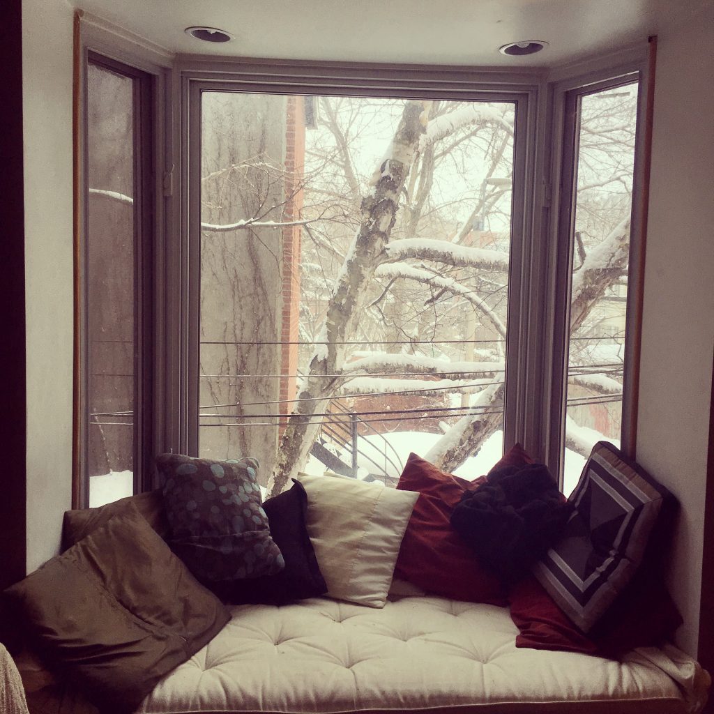 Une fenêtre typique avec un large rebords et des coussin avec vue sur la neige