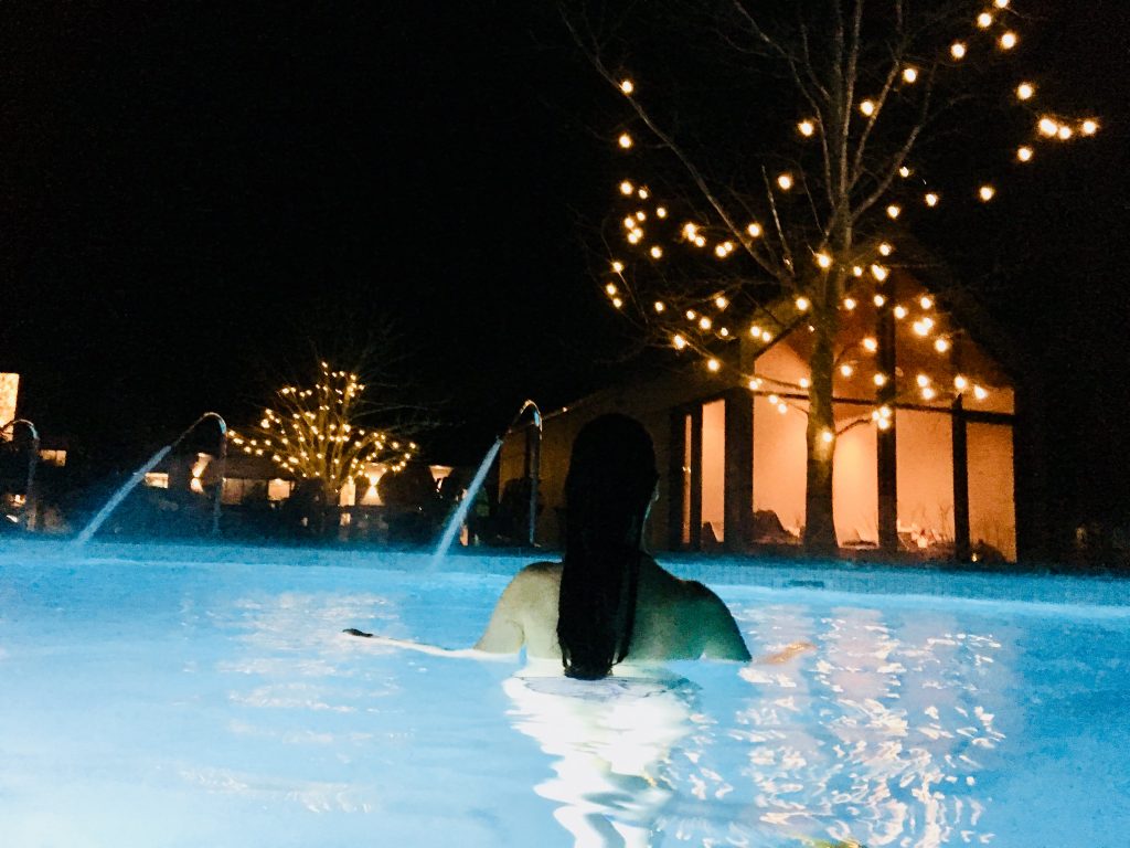 Jeune femme de dos dans la piscine chauffée spa nordique strom de mont saint hilaire