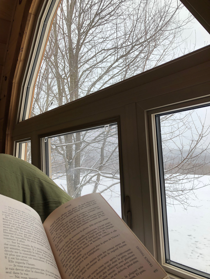 Lecture à la fenêtre avec vue sur la neige