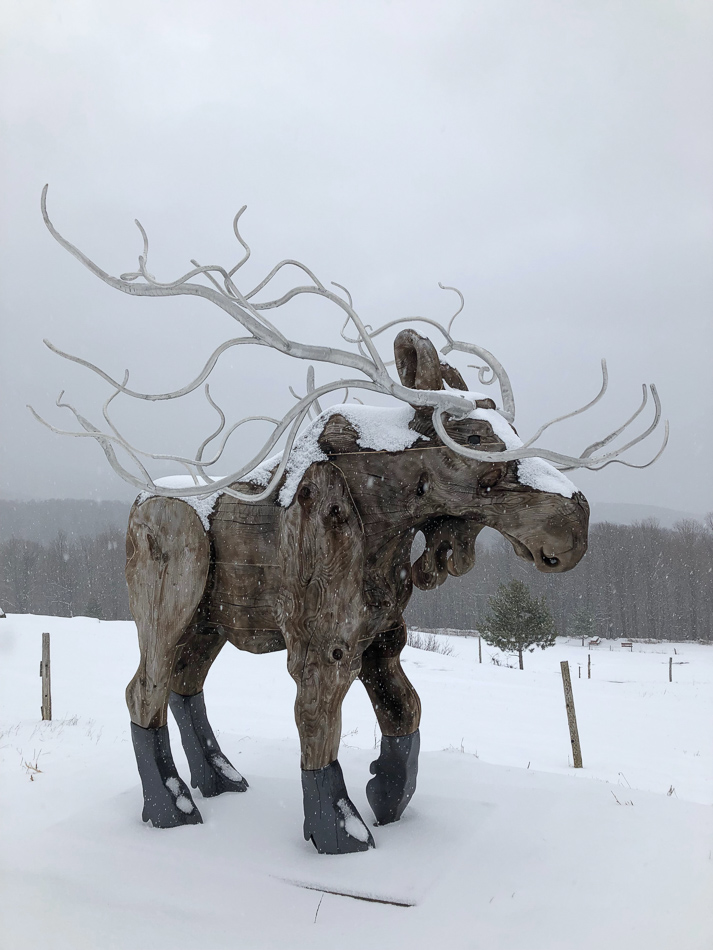 sculpture d'orignal en bois sous la neige au diable vert