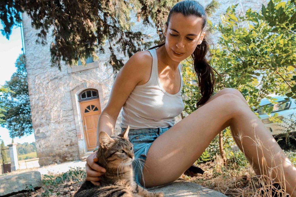 jeune fille qui caresse un chat dans la nature